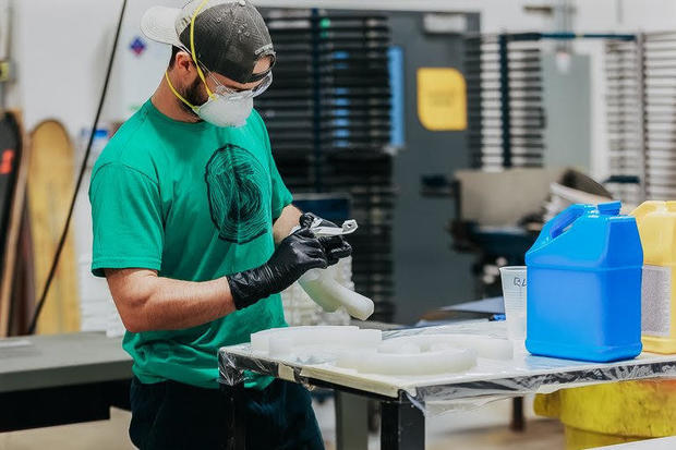 A Burton employee who used to make snowboards shifted to fabricating face shields for hospital workers at the company's 10,000 square-foot prototyping facility in Burlington, Vermont. COURTESY OF BURTON SNOWBOARDS